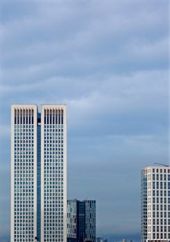 蓝天下的现代双子塔与周围摩天大楼的景色