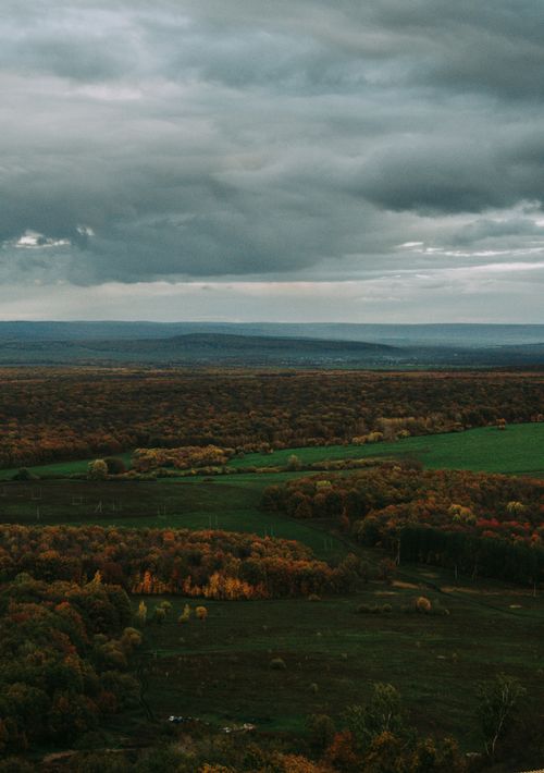 Free A view of Bashkortostan's autumn landscape with fields, forests, and hills under a cloudy sky. Stock Photo