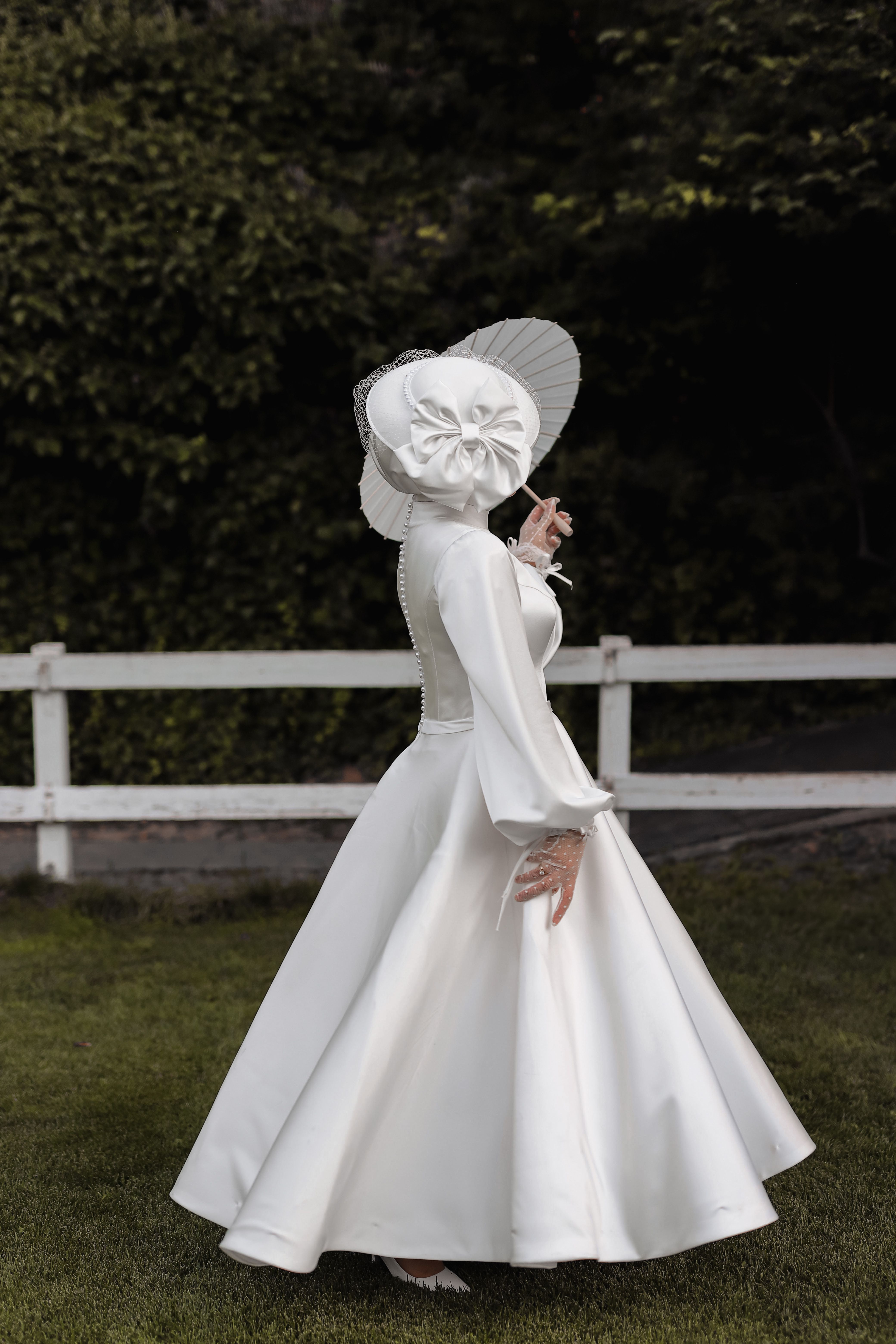 A woman in a white dress and hat walking on grass · Free Stock Photo