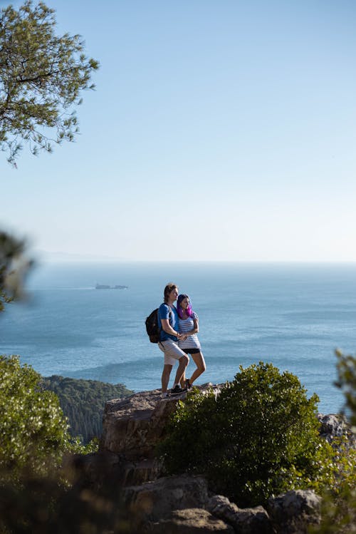 Free Man and Woman Standing on Cliff Stock Photo