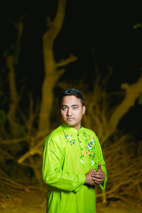 Free Vibrant portrait of a man in traditional Bangladeshi attire set against a natural background. Perfect for cultural themes. Stock Photo