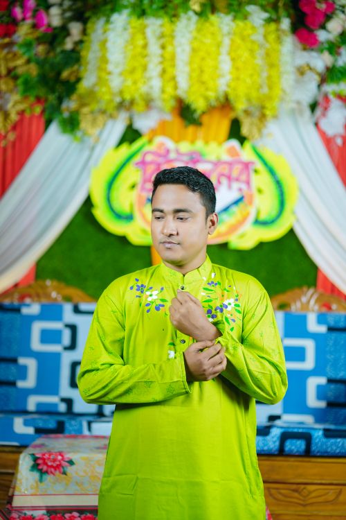 Free Man in vibrant traditional dress at a festive Bangladeshi wedding. Stock Photo