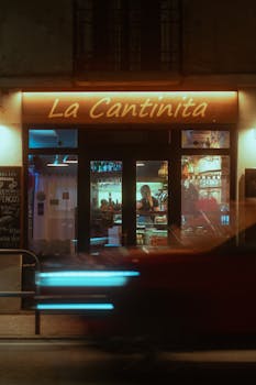 Vibrant bar scene at La Cantinita in Lido, showcasing nightlife with neon lights and motion blur effect.