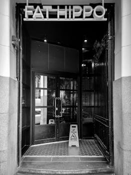 Monochrome image of the Fat Hippo entrance in Glasgow, highlighting urban architecture.