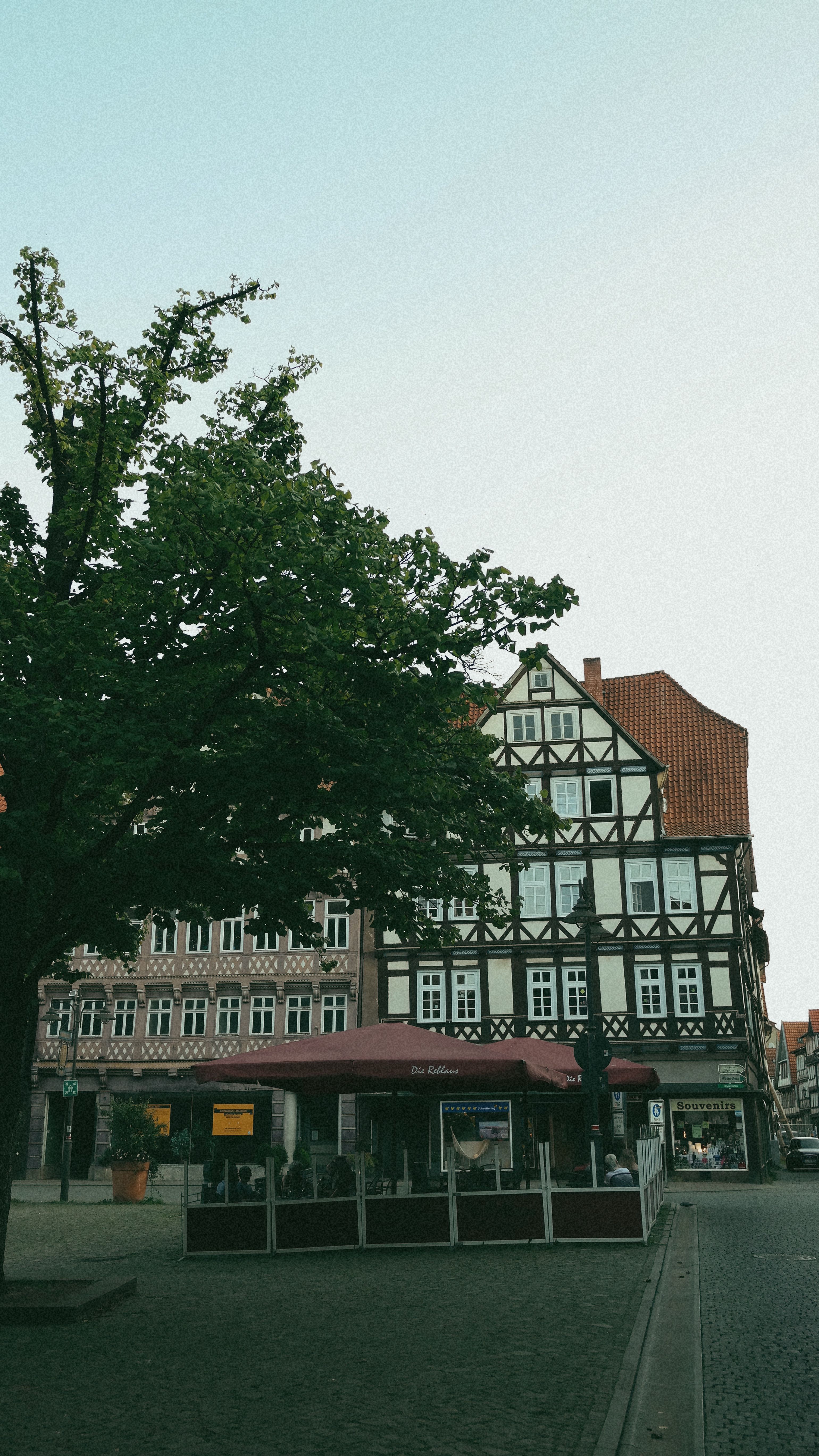 Picturesque half-timbered house in a quaint town square with tree-lined streets.