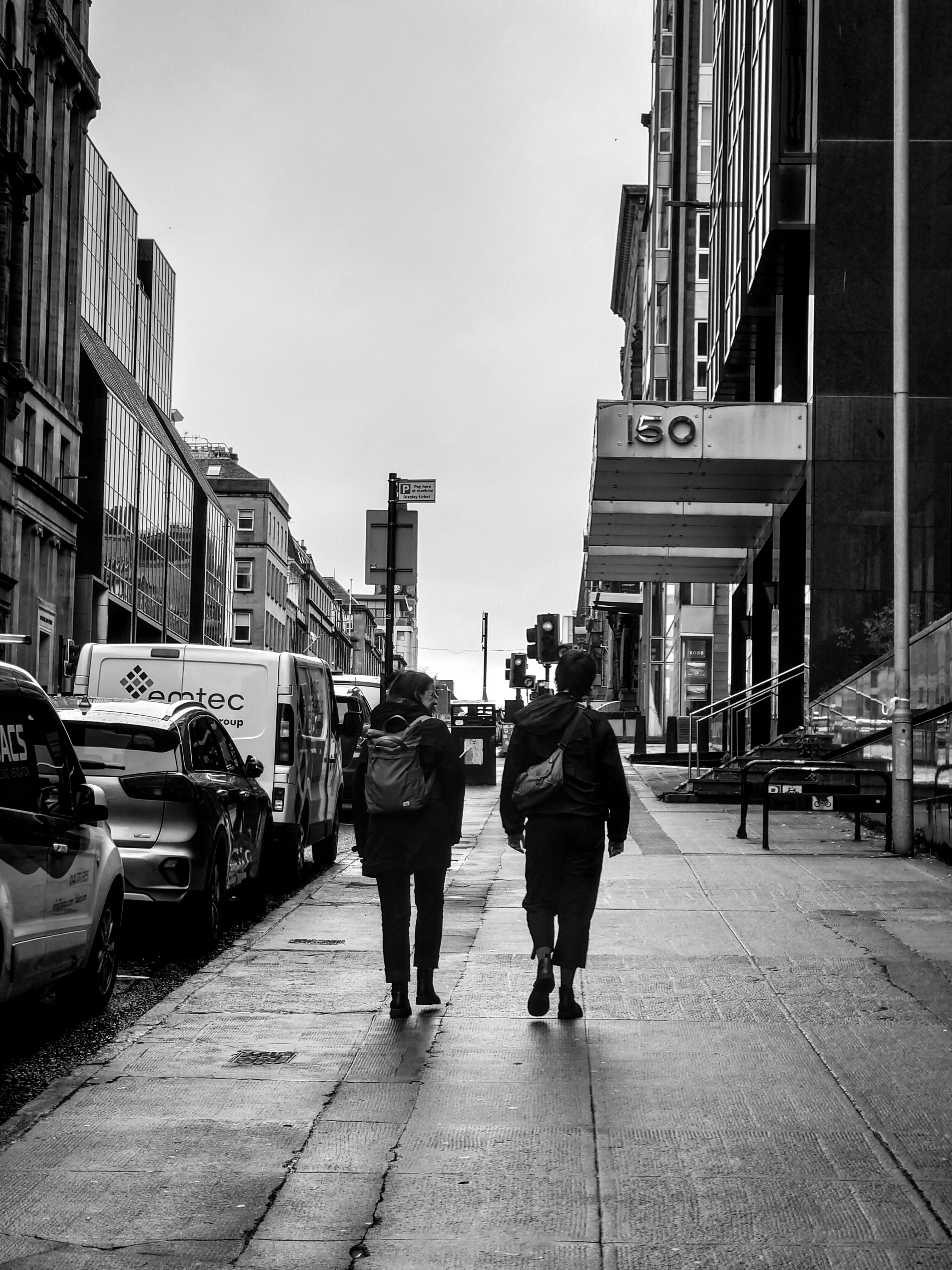 Two people walking down a sidewalk in a city · Free Stock Photo