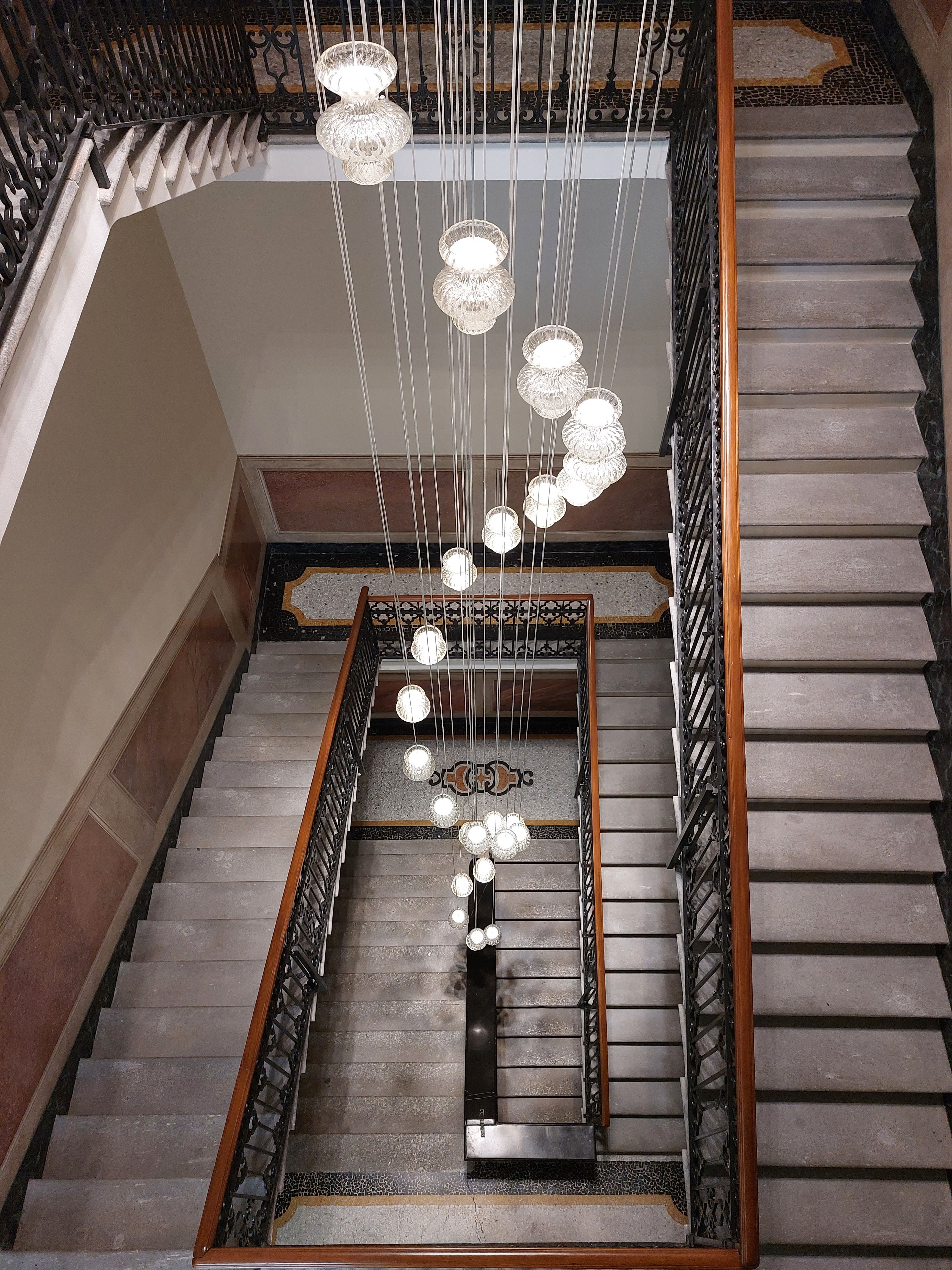 A staircase with lights hanging from the ceiling · Free Stock Photo