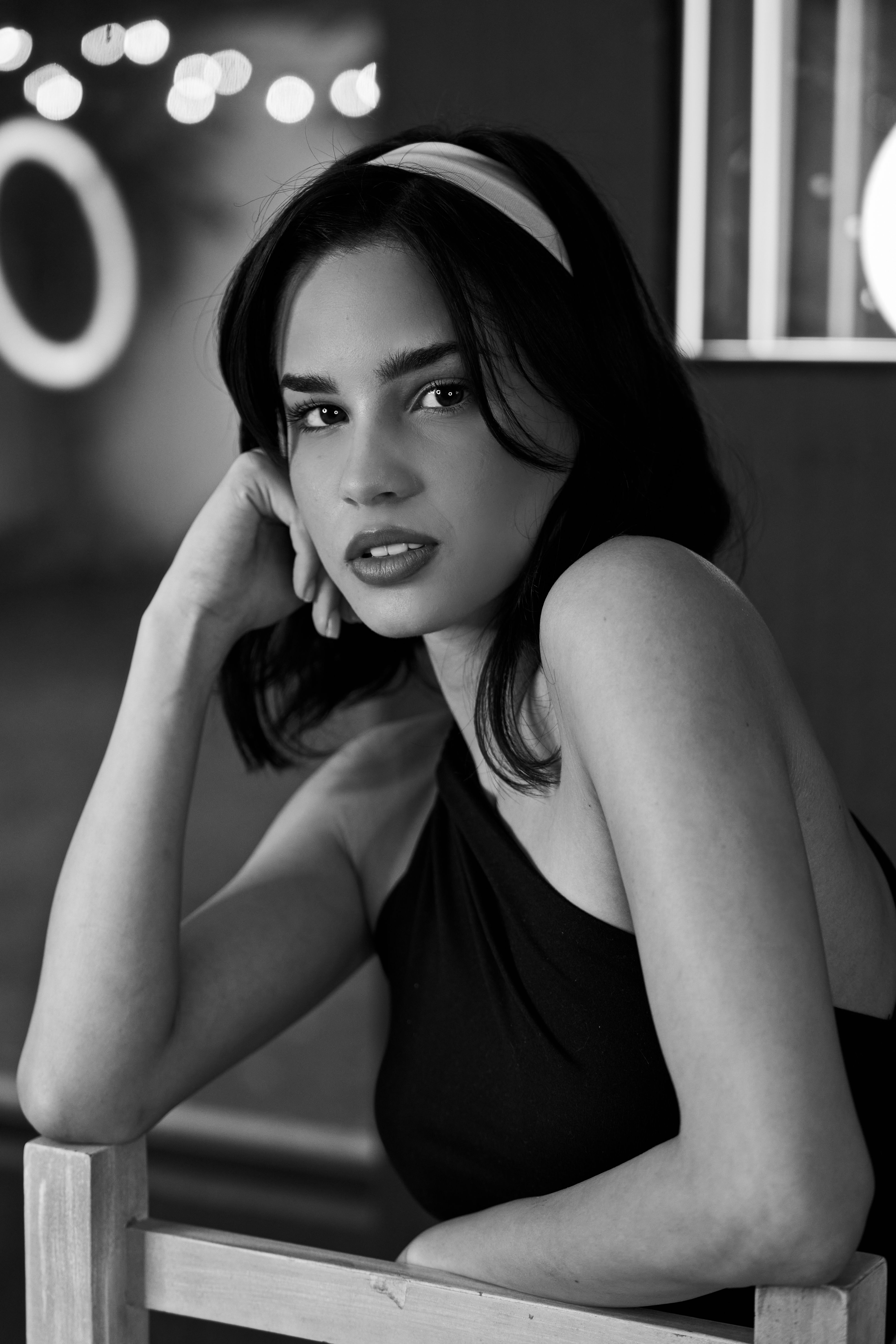 A woman in a black dress sitting on a chair · Free Stock Photo