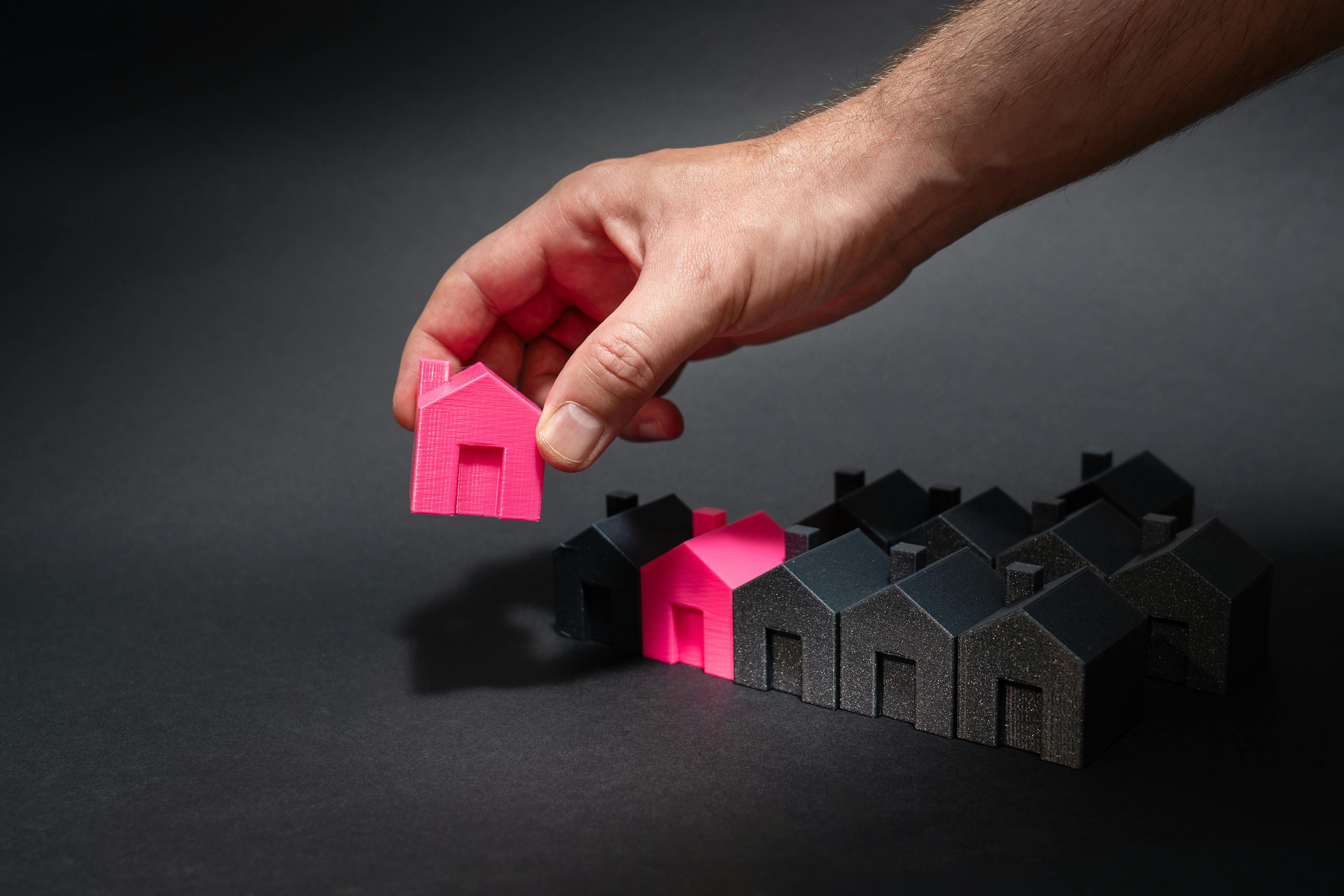  A picture of a hand of a person holding a house model