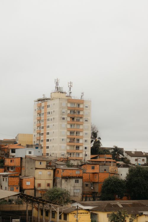 Free Aerial view of a cityscape featuring high-rise and traditional buildings on a cloudy day. Stock Photo