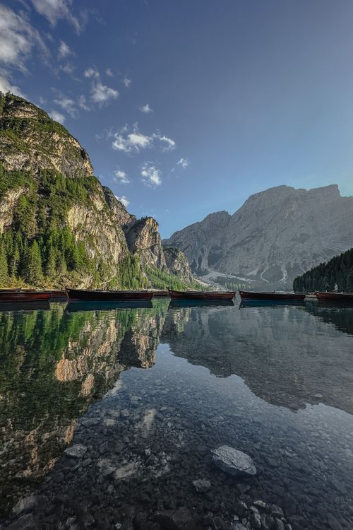 Free Serene lake surrounded by majestic mountains under a clear sky, perfect for nature lovers. Stock Photo
