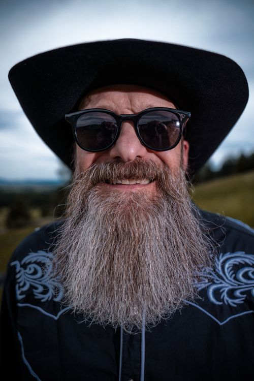 Free A bearded man wearing sunglasses and a cowboy hat outdoors. Perfect for Western themes. Stock Photo
