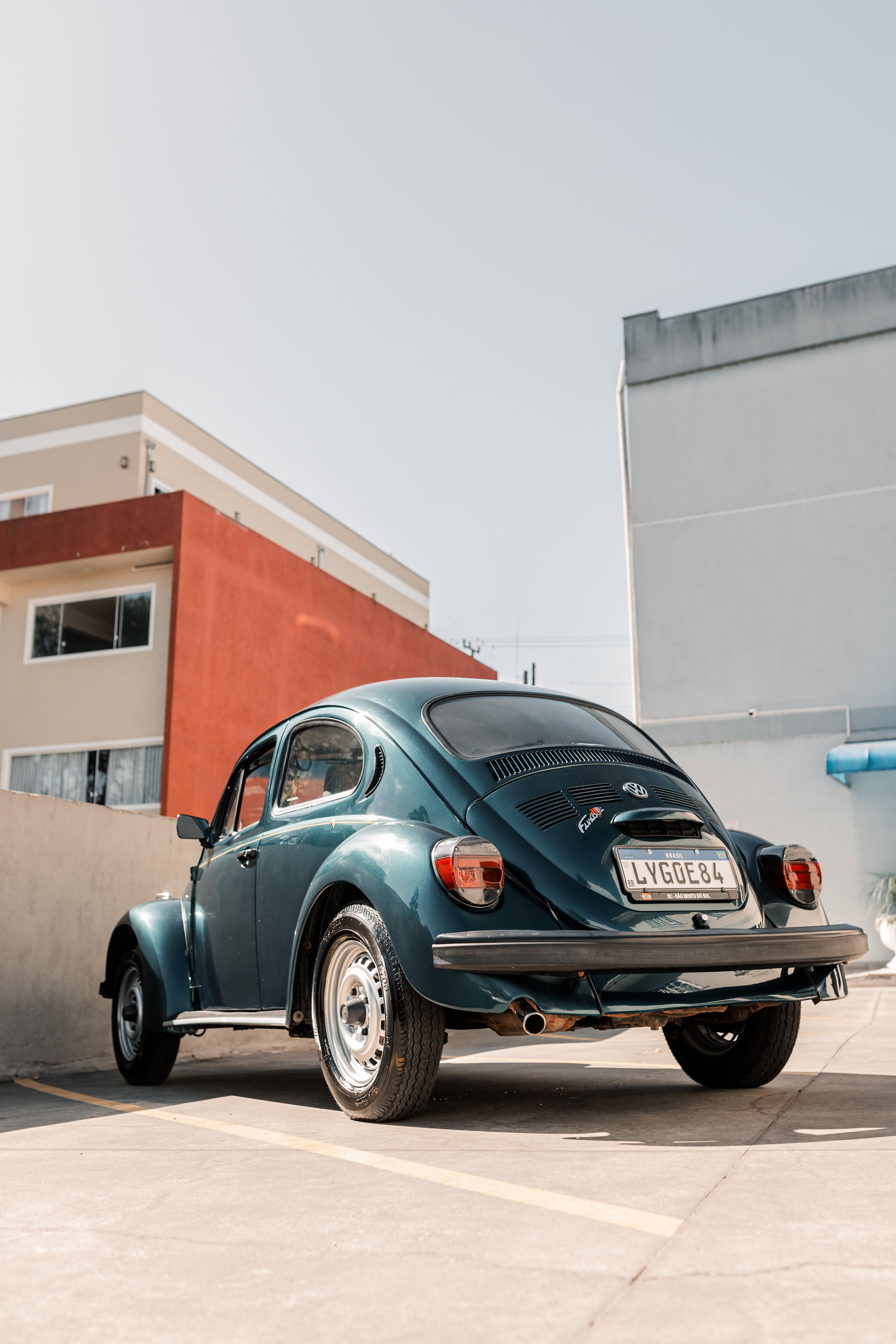 A green volkswagen beetle parked in front of a building · Free Stock Photo