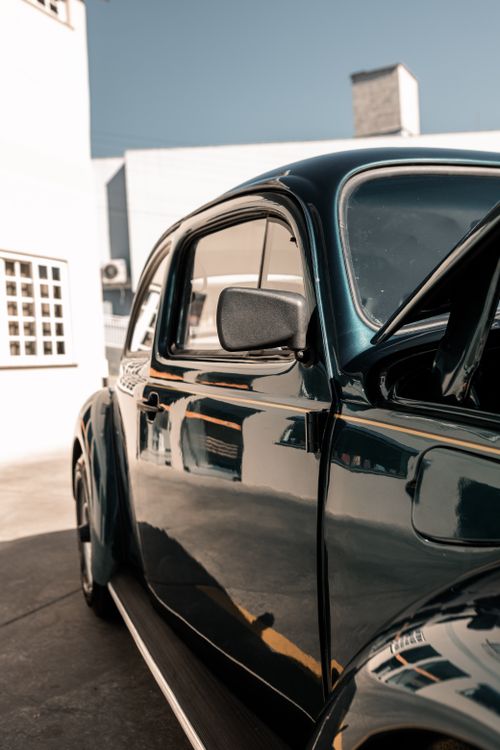 Free Close-up of a vintage black car parked in a sunlit urban area. Stock Photo