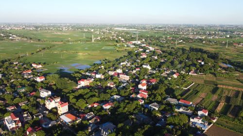 Free Aerial view of vibrant Vietnamese village surrounded by lush fields during daytime. Stock Photo
