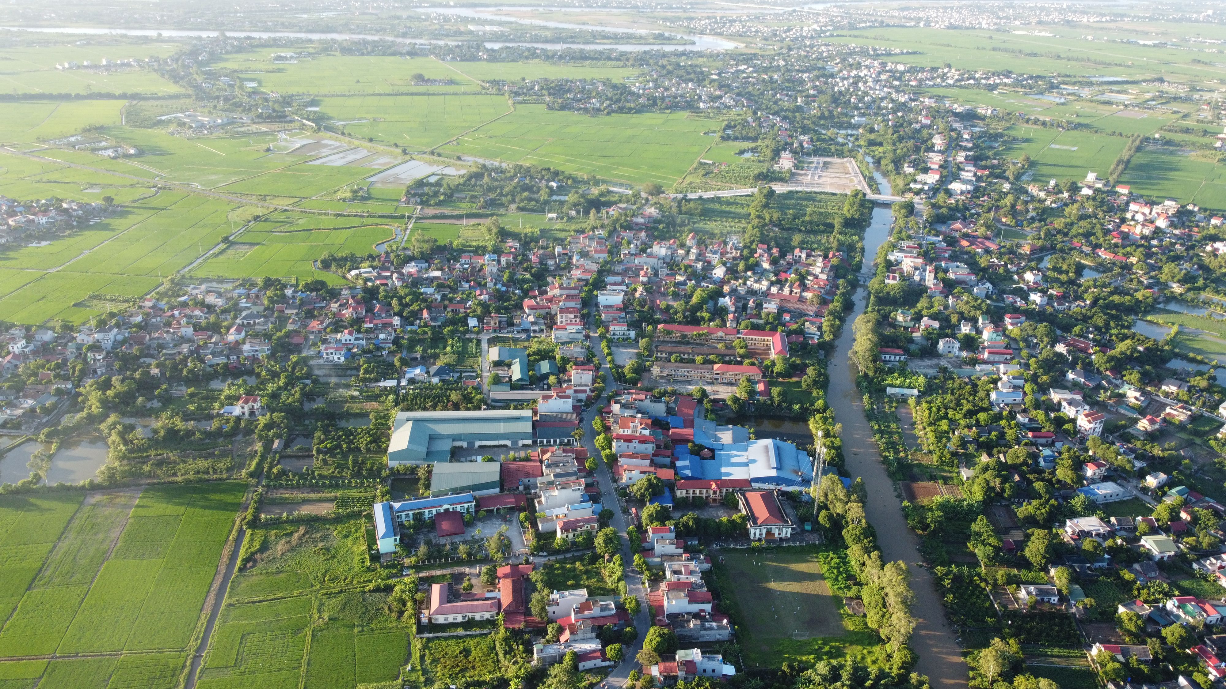Aerial shot of a serene rural landscape in Vietnam with fields and rivers.
