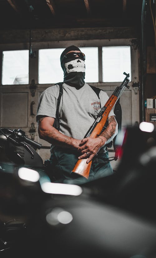 Man Wearing Mask Carrying Rifle