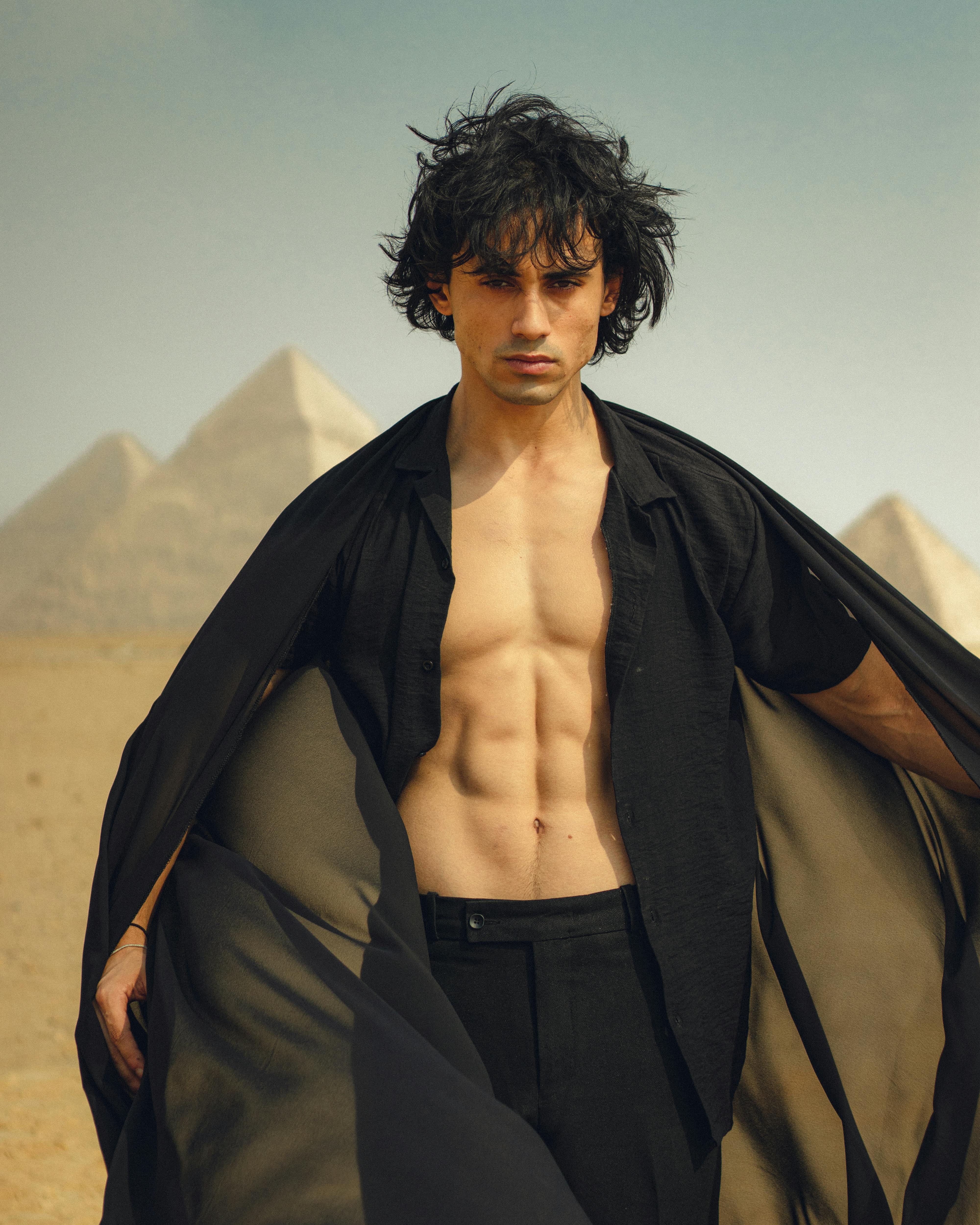 a man posing in front of the pyramids