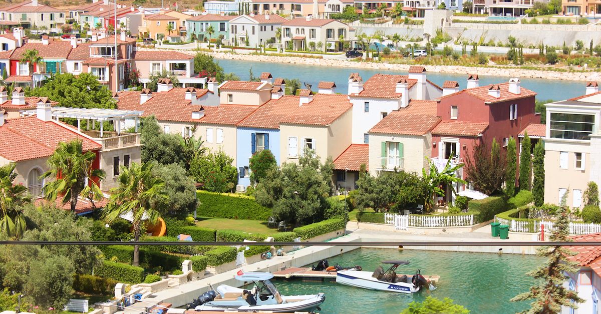Beautiful Mediterranean houses by a canal, perfect for a luxury vacation retreat.