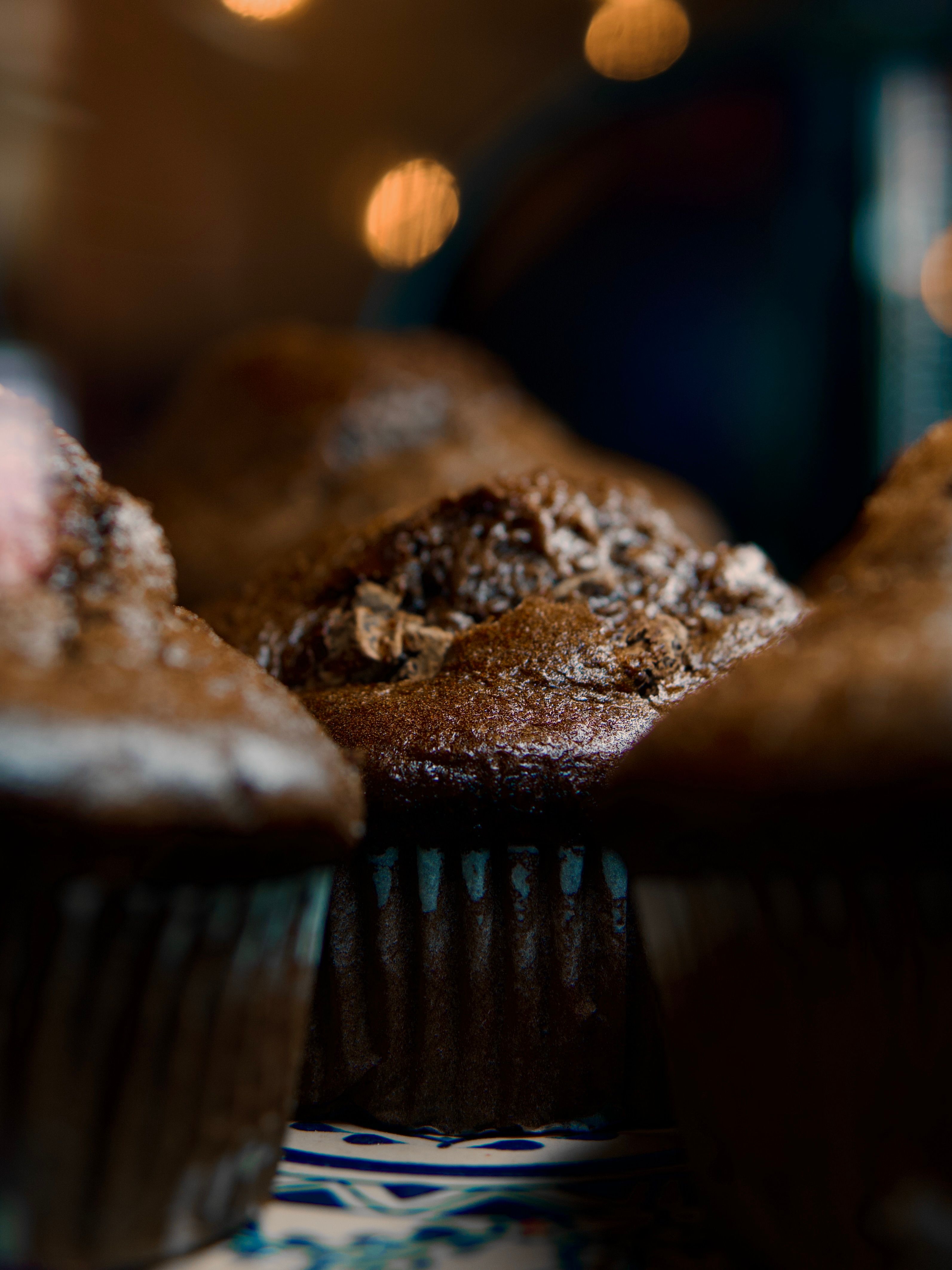 Delicious homemade chocolate muffins shot in a warm café ambiance, perfect for indulgent moments.