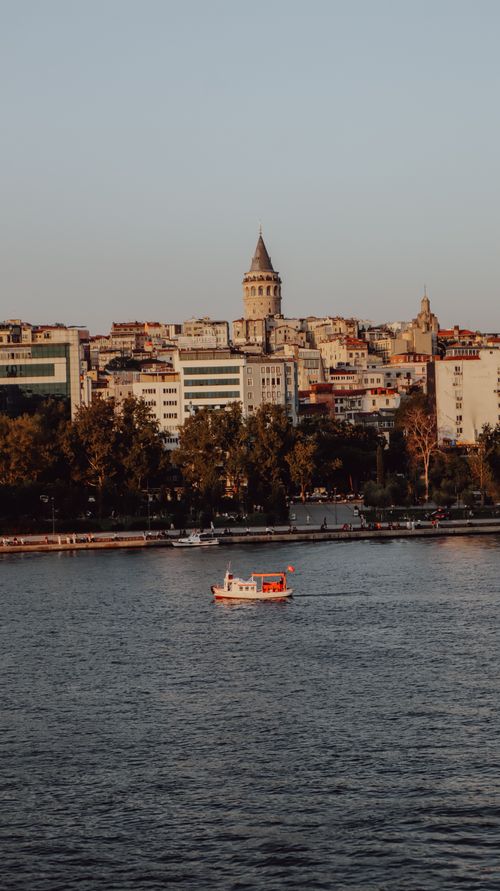 Free Scenic view of Galata Tower with a boat on the Golden Horn in Istanbul, Turkey. Stock Photo