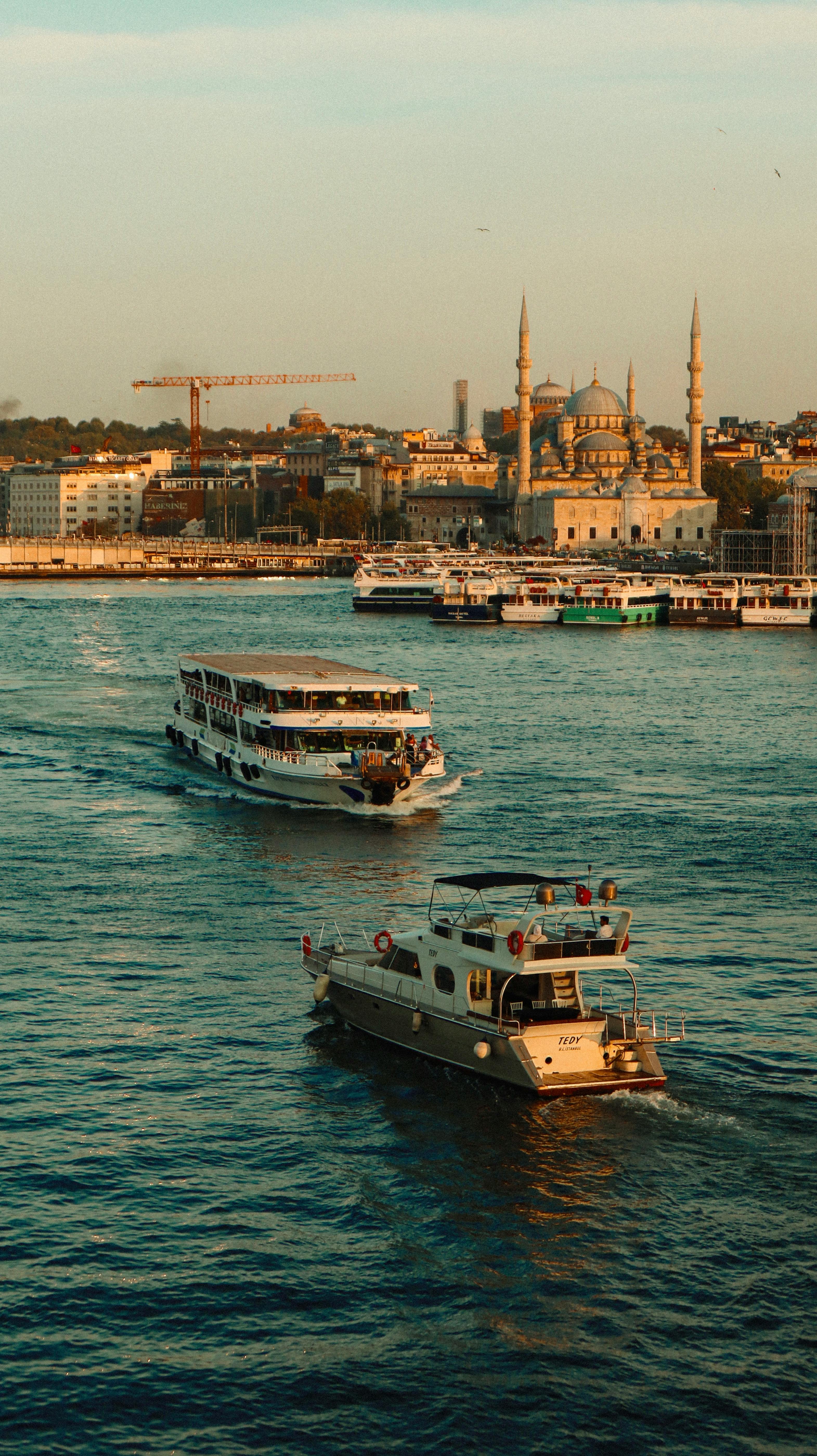 two boats are traveling down the water in front of a city