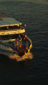 A passenger ferry sailing through serene waters during sunset, capturing a tranquil travel moment.