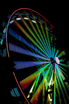 Vibrant ferris wheel with LED lights spinning at night in Cairns, Australia.