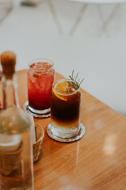 Close-up of refreshing cocktails with garnish on a wooden caf茅 table, perfect for a summer day.