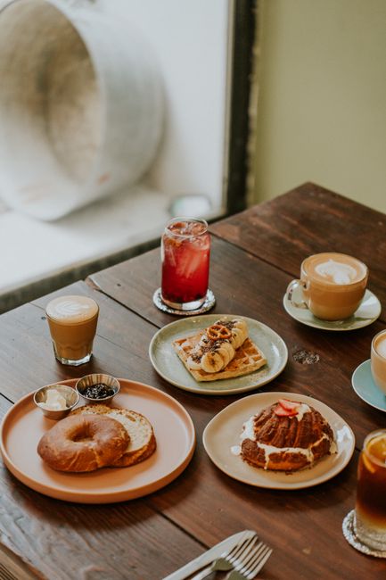 Inviting breakfast spread with coffee, pastries, and refreshing drinks at a cozy café table.