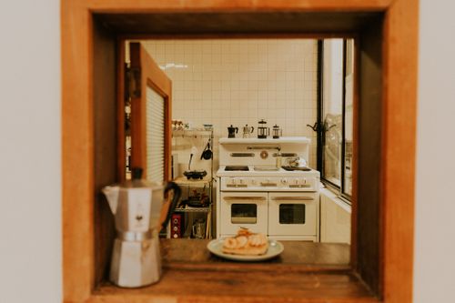 Free Interior view of a cozy retro kitchen featuring a vintage stove and coffee setup. Stock Photo