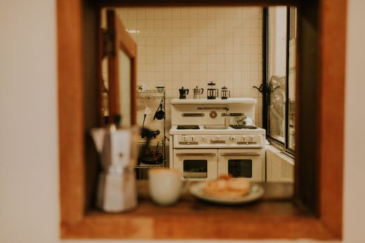 A warm and inviting view into a vintage kitchen featuring a classic stove and coffee setup
