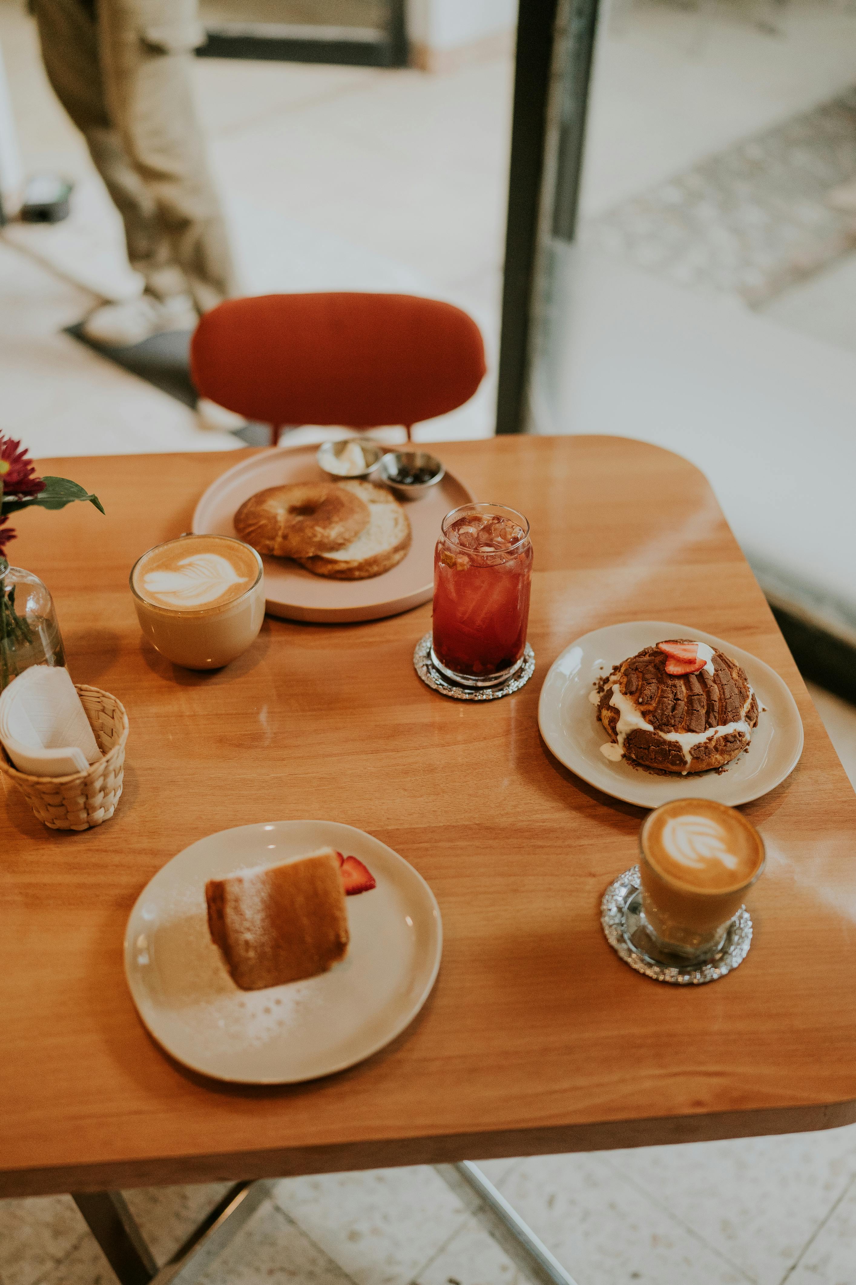 a table with coffee pastries and other food