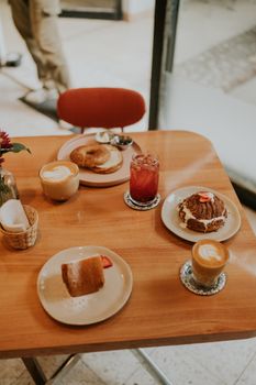 A cozy café table set with coffee, pastries, and juice creating a warm breakfast scene.