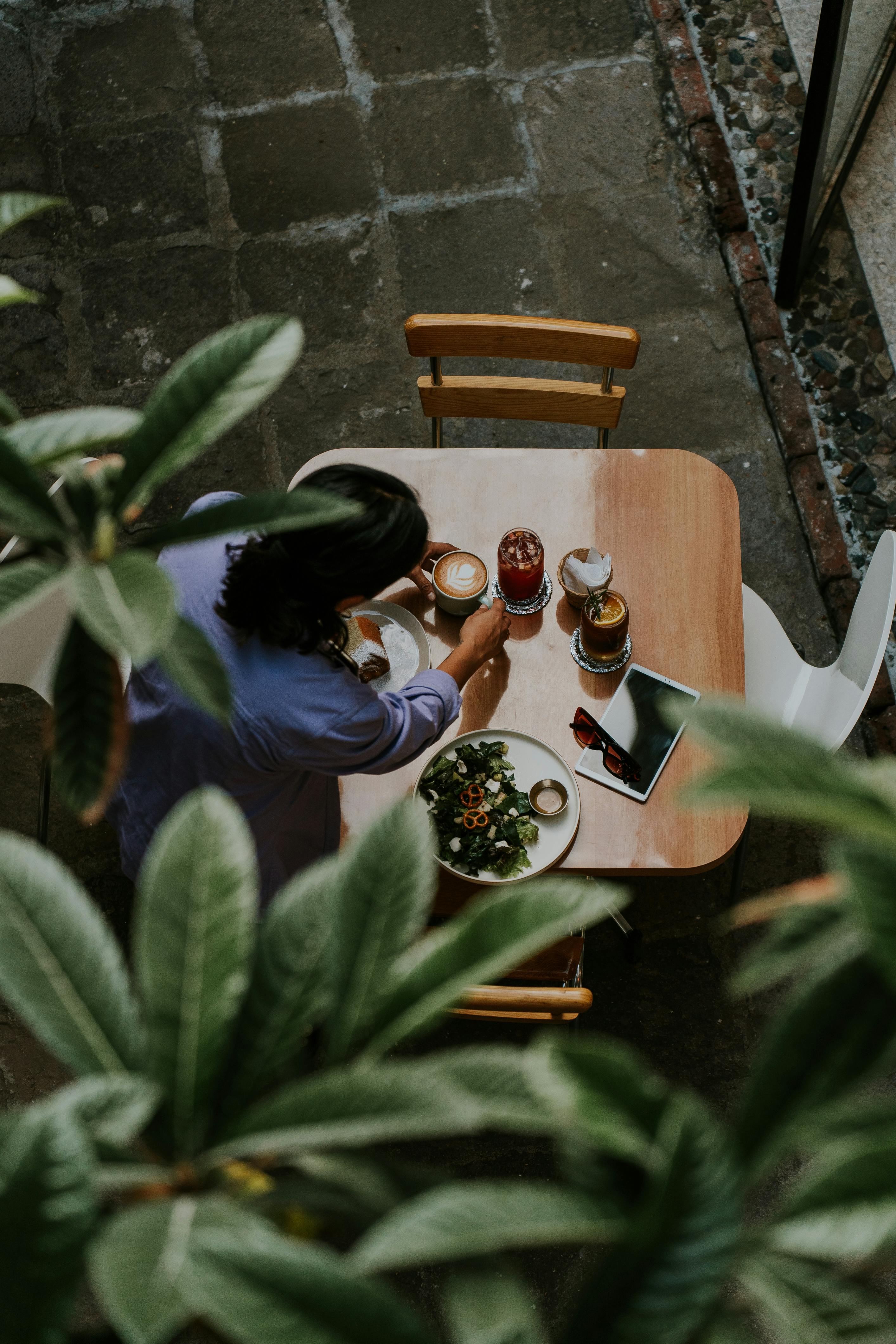 a woman sitting at a table with a drink