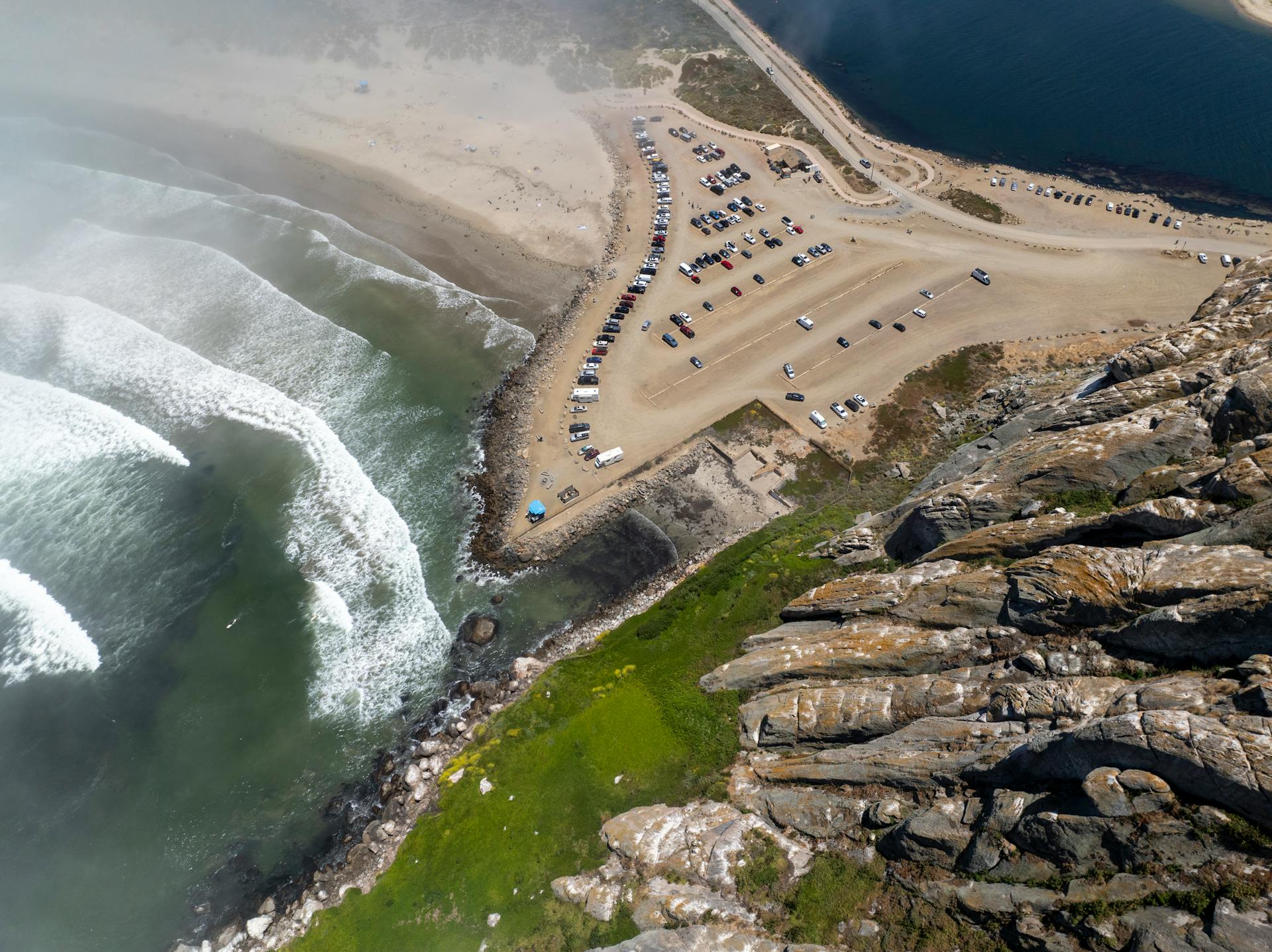 Stunning aerial view of Morro Bay beach with waves and rocky coastline.
