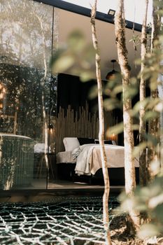 Serene glass wall bedroom in a forest cabin, perfect retreat.