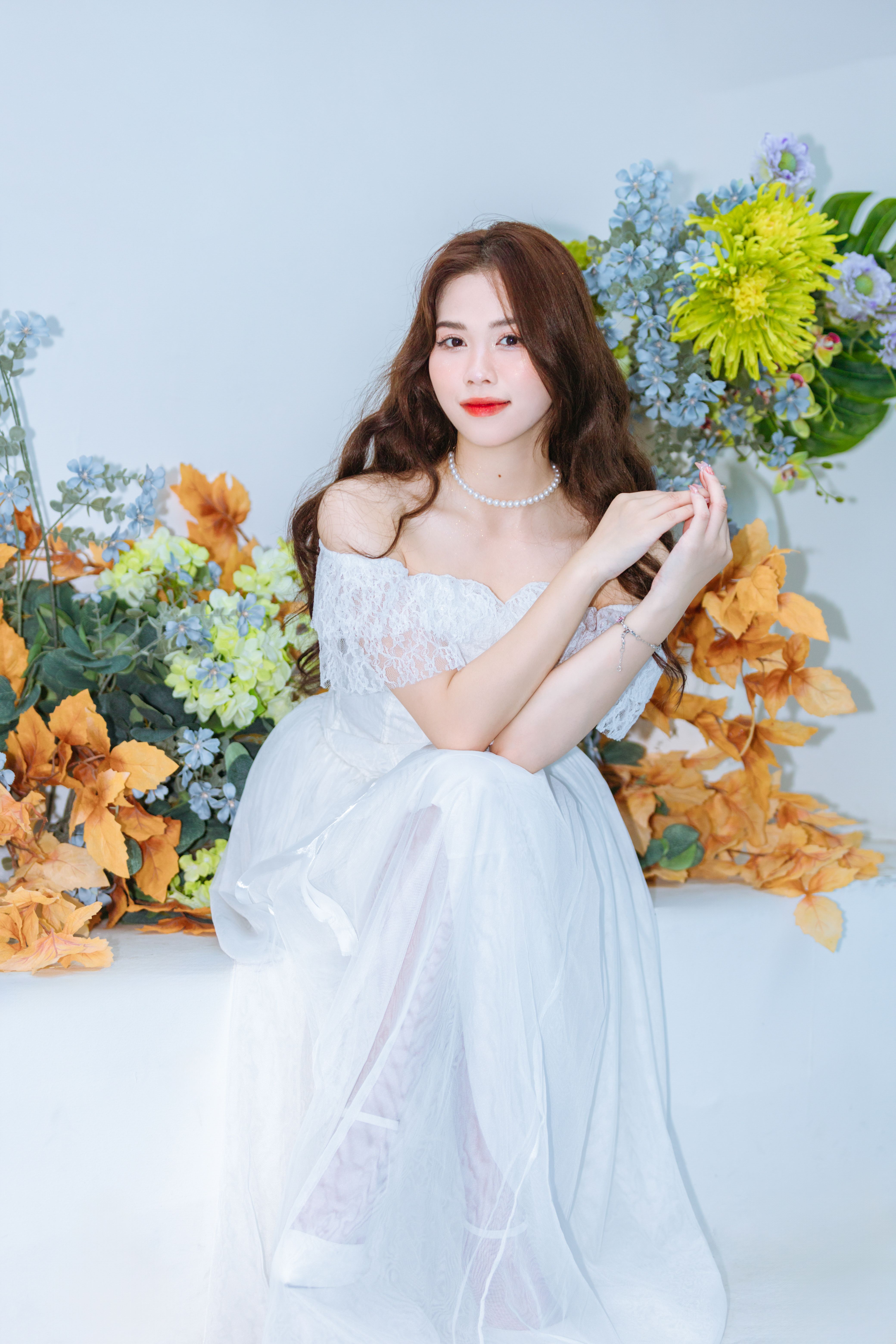 A woman in a white dress sitting on a bench · Free Stock Photo