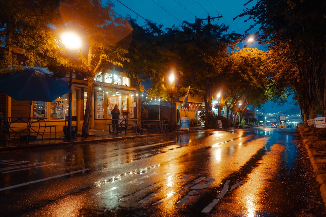 A rainy night scene with street lights and cars · Free Stock Photo