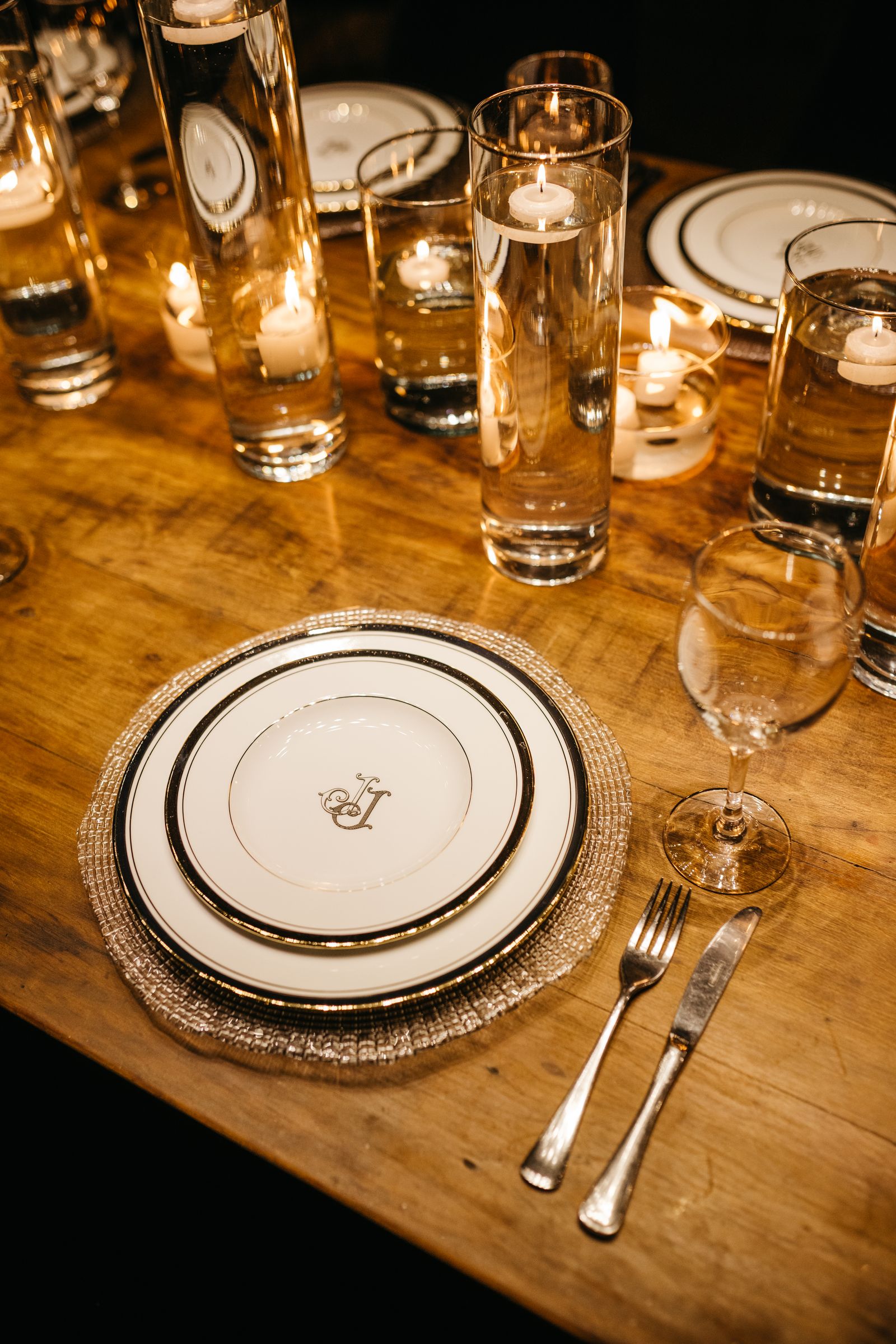A dinner table laid with candles and glassware