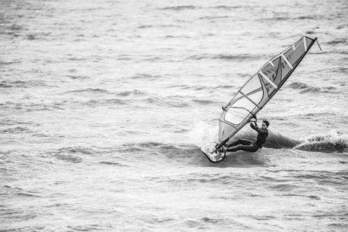 Grayscale Photography of Man Riding on Sailing Surf