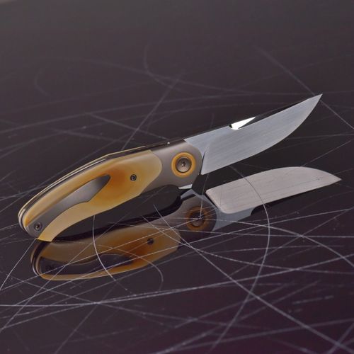 Free Sleek folding knife with steel blade and ergonomic handle on a scratched reflective surface. Stock Photo