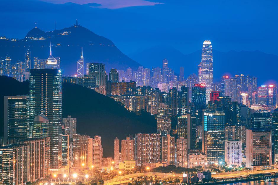 financial considerations for international expansion - Stunning aerial view of Hong Kong skyline illuminated at night, showcasing modern skyscrapers against a mountainous backdrop.