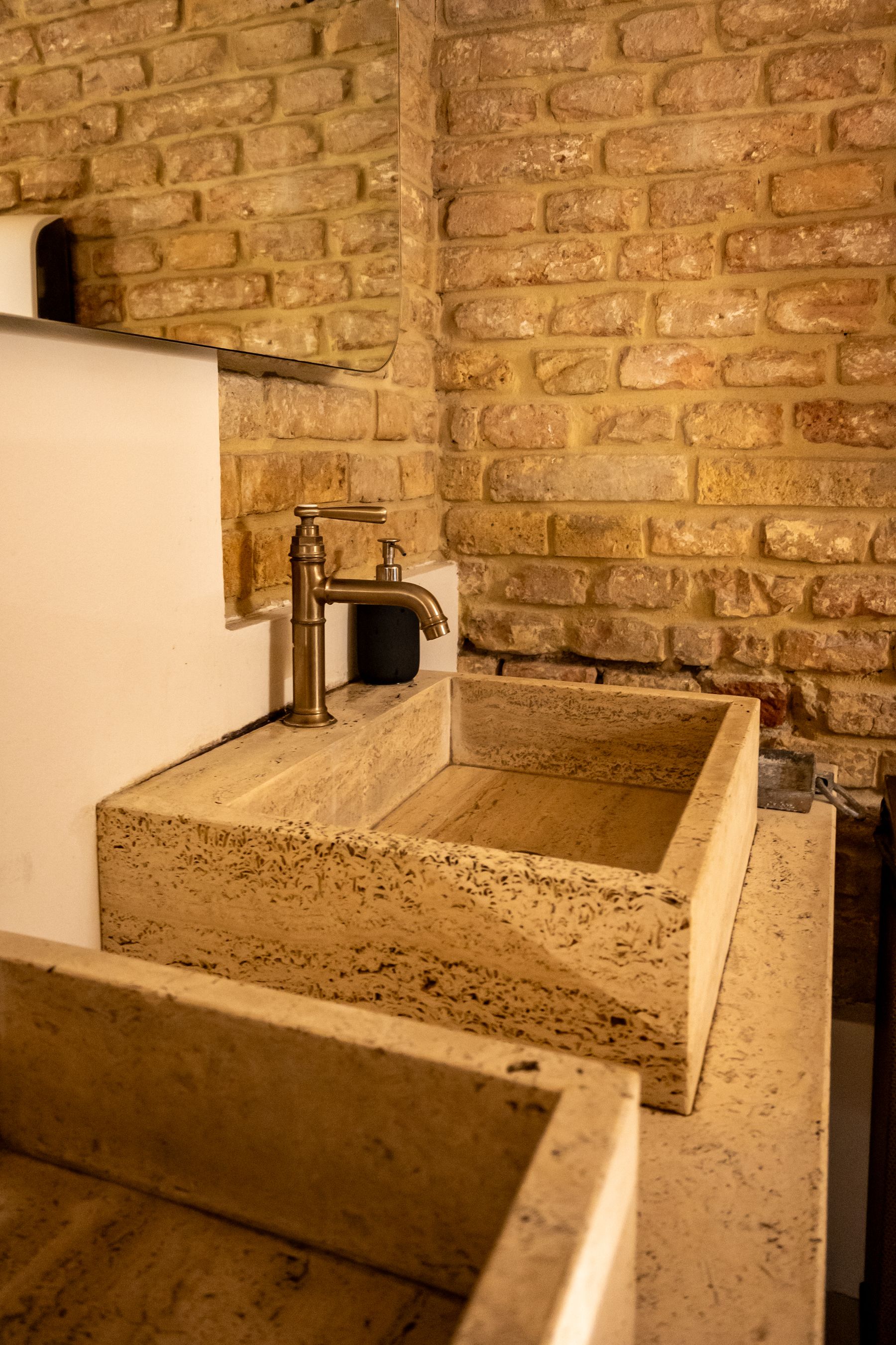Industrial bathroom with substantial stone sink and simple surrounding surfaces