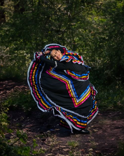 Free Woman in colorful traditional dance costume spinning outdoors in lively motion. Stock Photo
