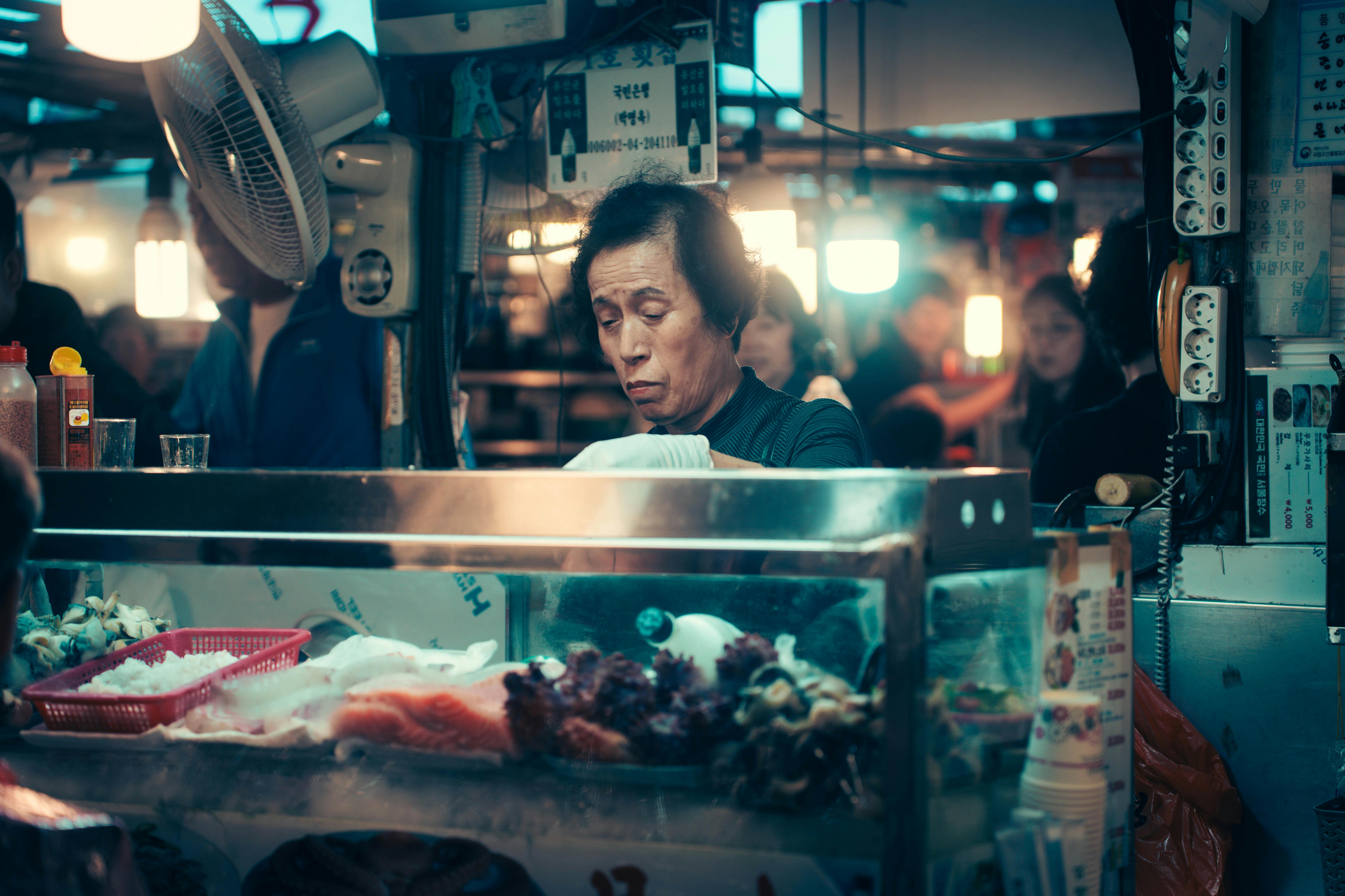 A bustling Korean food market stall in Seoul, featuring fresh seafood and a vibrant atmosphere.
