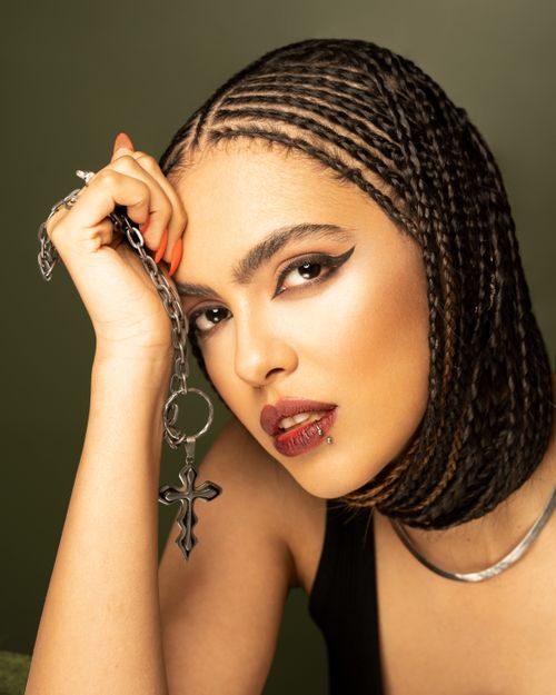 Free Close-up portrait of a woman with braids holding a chain accessory. Stock Photo