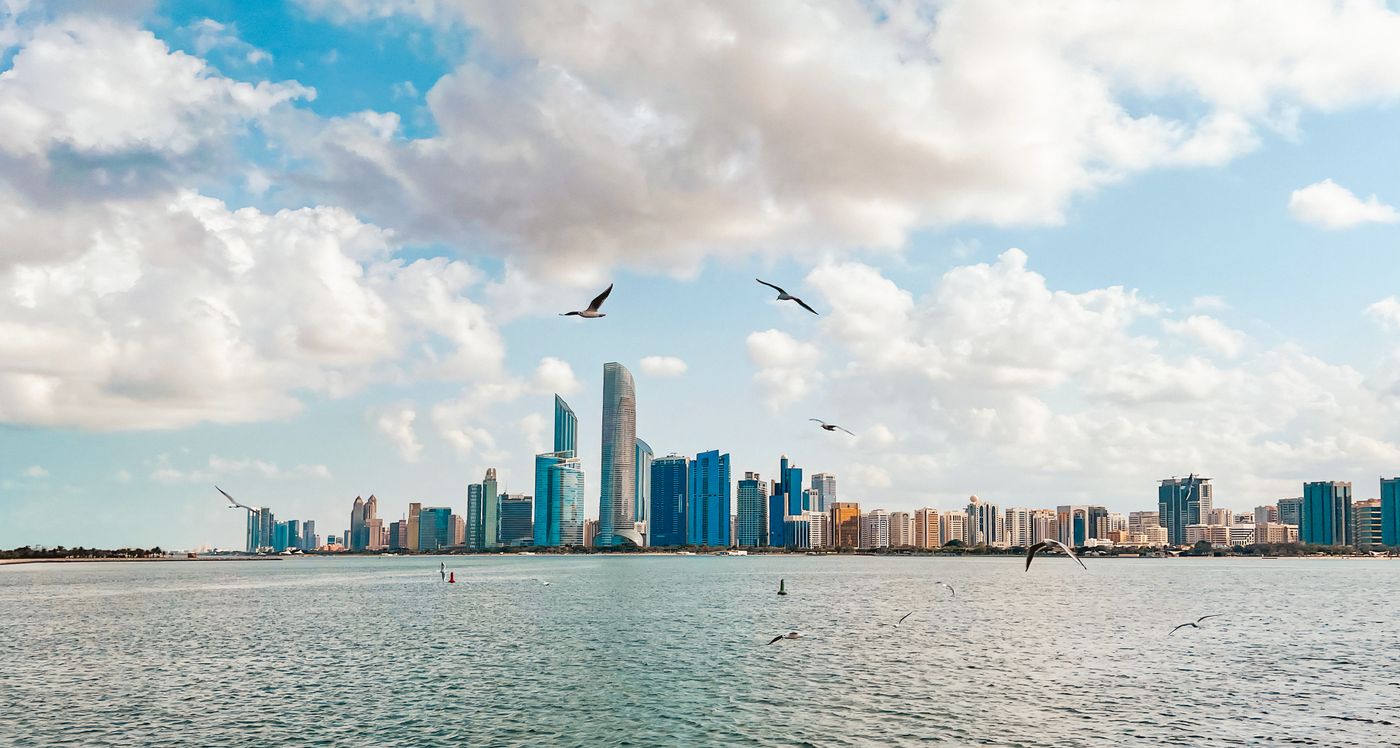 Abu Dhabi Corniche skyline across the water with birds in daylight