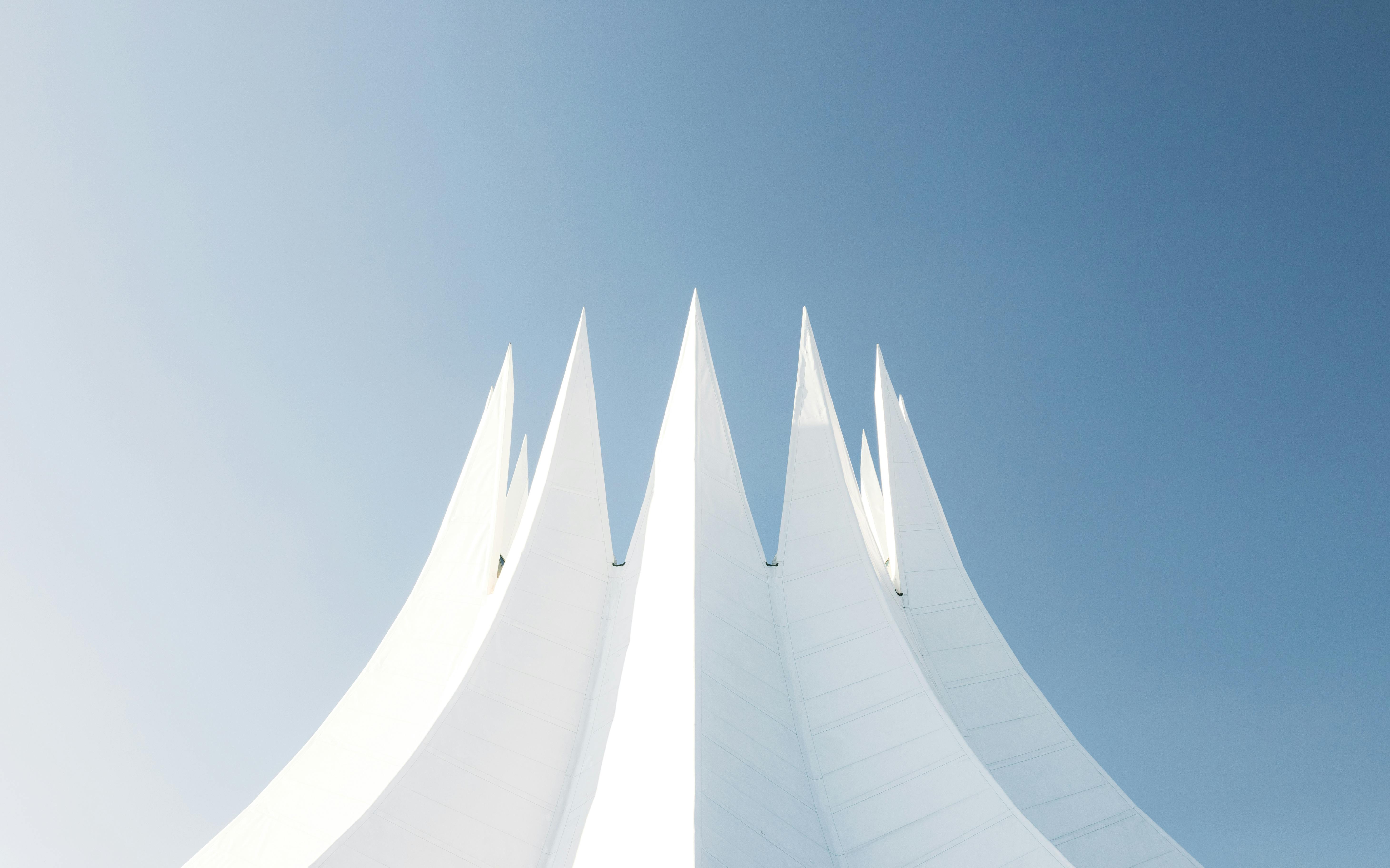 Minimalist view of the Tempodrom in Berlin with clear blue sky background, showcasing its modern design.