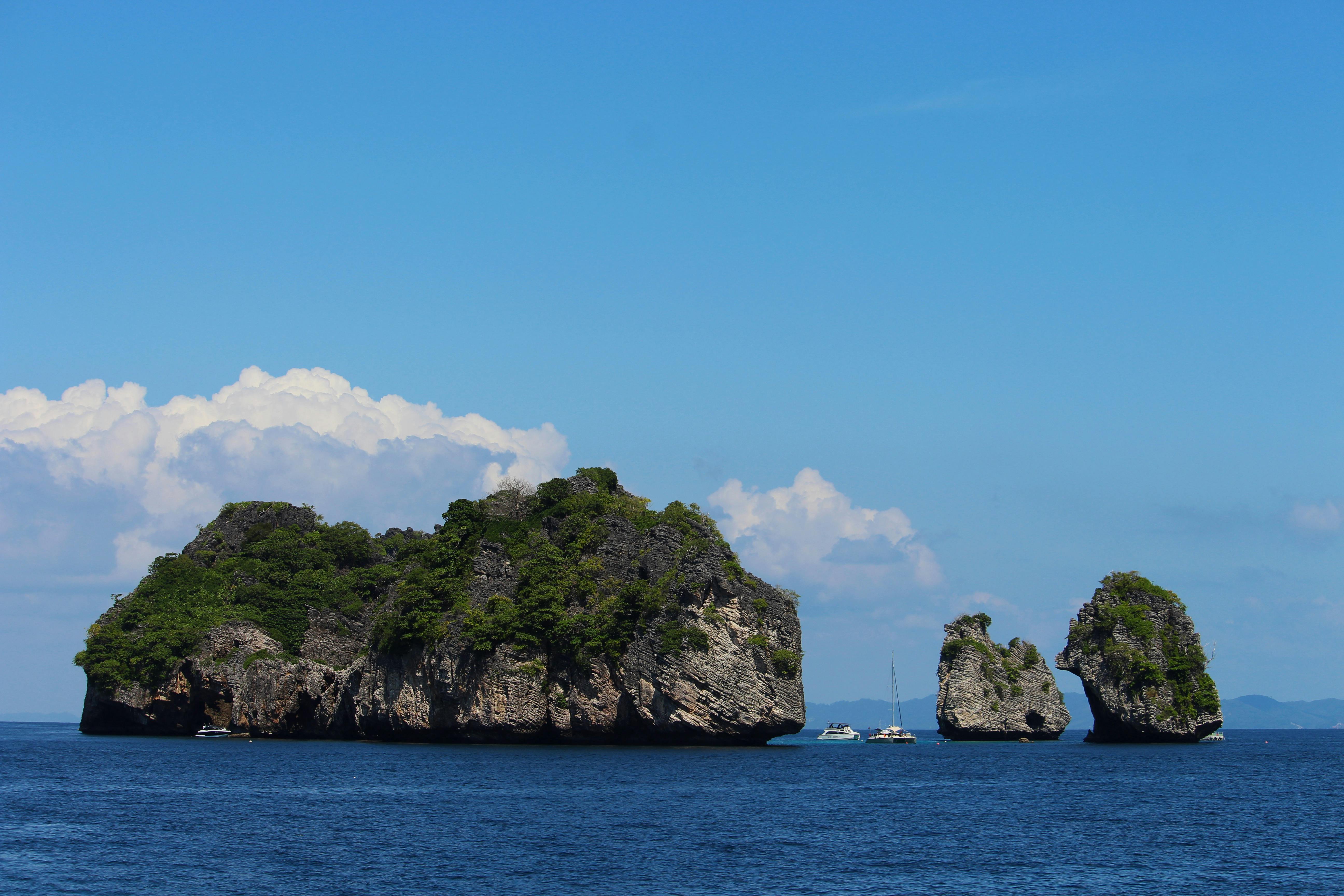 a group of small islands in the ocean with a boat in the middle